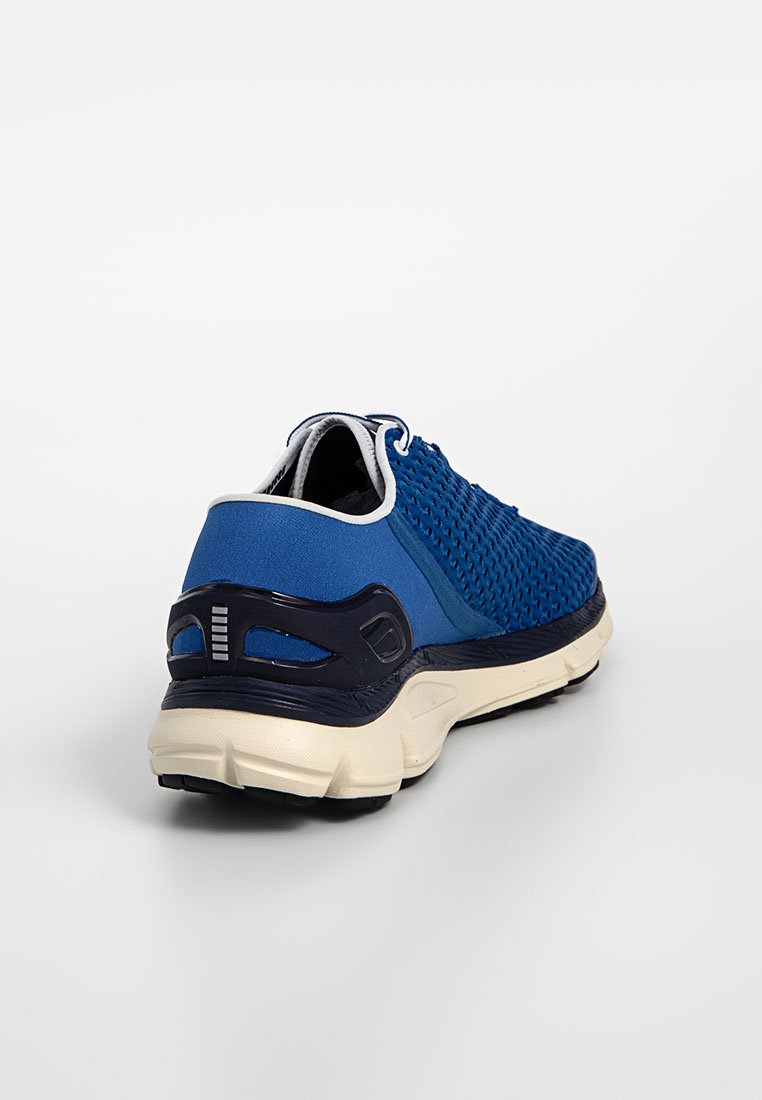 Zapatilla deportiva azul con una parte superior de malla texturizada, acentos en marino contrastantes y una suela acolchada en un tono blanco roto con elementos de diseño que brindan soporte.