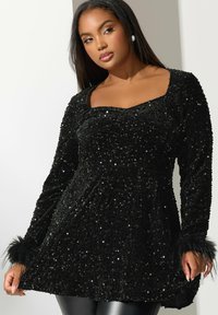Top nero con scollatura quadrata, decorato con paillettes, maniche lunghe con dettagli in pelliccia sui polsini e una texture liscia.