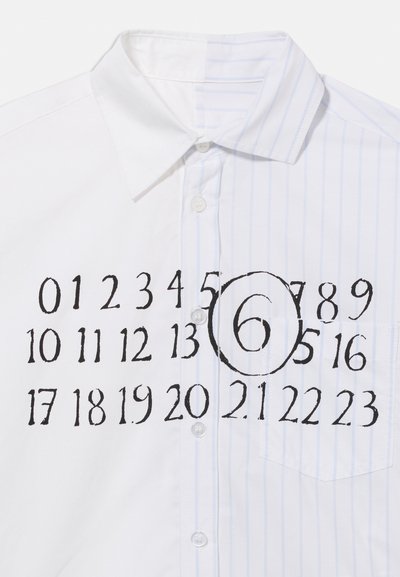 Λευκό πουκάμισο με κουμπιά, με κάθετες ανοιχτό μπλε ρίγες και μαύρους αριθμούς από το 0 έως το 23 τυπωμένους στο στήθος, με τον αριθμό 6 κυκλωμένο.