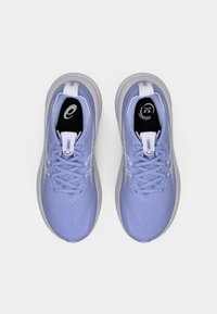 Jasnofioletowe buty sportowe z fakturowaną cholewką, z zapięciem na sznurówki i białymi akcentami. Posiadają amortyzowaną podeszwę i logo na języku.