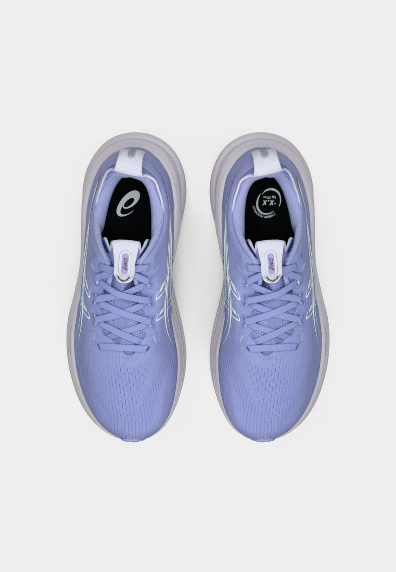 Baskets de sport violet clair avec dessus texturé, fermeture à lacets et accents blancs. Présentent une semelle rembourrée et un logo sur la languette.