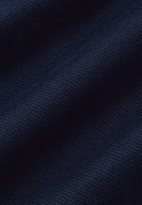 Granatowa teksturowana tkanina z delikatnym wzorem tkanym, charakteryzująca się gładkim układaniem i miękkim wykończeniem, odpowiednia do różnych zastosowań tekstylnych.