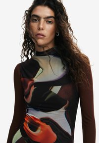 Rochie cu mâneci lungi, având un model abstract multicolor în nuanțe de brun, roșu și verde, confecționată dintr-un material neted și elastic.