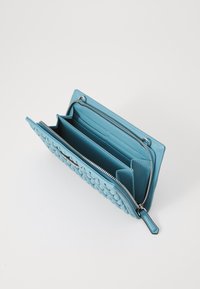 Light blue leather wallet with a textured exterior, zip closure, multiple card slots, and spacious compartments for organization.
