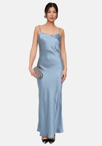 Hellblaues Satinkleid mit Spaghettiträgern, bodenlang, glatte Textur, figurbetonte Silhouette, kombiniert mit einer schwarz-weiß gestreiften Clutch und schwarzen High Heels.