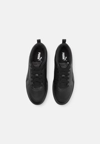 Chaussures de sport noires avec empeigne en cuir lisse, lacets ton sur ton, col rembourré et détails perforés sur l'avant-pied.