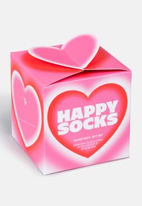 Ružová papierová darčeková krabička s viečkom v tvare srdca, na ktorom je biely text "HAPPY SOCKS" a "VALENTINE'S GIFT SET."