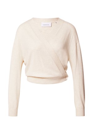 Maglione cropped beige chiaro con design avvolgente, maniche lunghe e texture morbida. Presenta una piccola decorazione a bottone su un lato.
