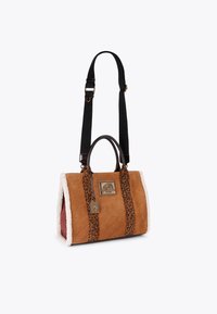Borsa a mano in similpelle marrone con motivo a onde in rilievo, manici in stampa leopardata, bordi in peluche bianco e una placca metallica decorativa.
