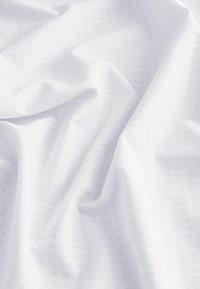 White fabric with a woven grid pattern, featuring a smooth texture and soft drape, highlighting subtle tonal variations.
