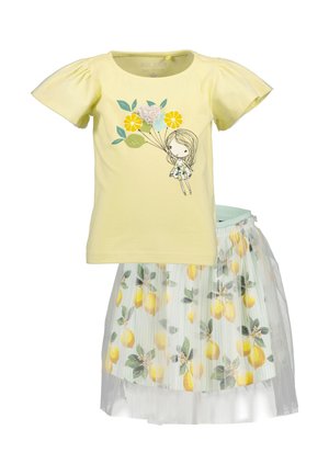 Gul bomuld T-shirt med pufærmer og citronmotiv, kombineret med et plisseret nederdel med citronmønster og tyl-overlay.