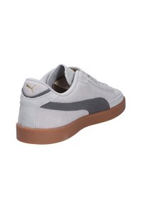 Hellgraue Wildleder-Sneaker mit dunkelgrauem Streifen, Gummisohle, gepolstertem Kragen und strukturierten Details an den Seiten. Schnürsenkel und Logo-Akzent.