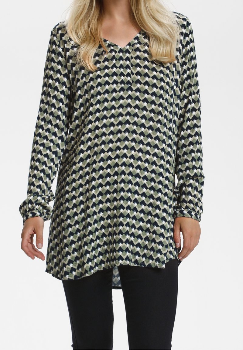 Tunique à manches longues avec un col en V, présentant un motif géométrique en vert, marine et crème. Tissu léger avec une coupe décontractée et un ourlet arrondi.