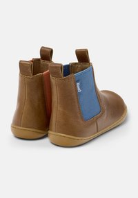 Botas de cuero marrón hasta el tobillo con paneles elásticos; acentos en azul y rojo en los costados, suela de goma y un acabado suave.