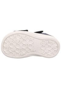 Weiße Gummisohle eines Kinderschuhs mit Herz- und Kettenmuster, Markenname "superfit" und Größe "20" auf der Sohle eingeprägt.