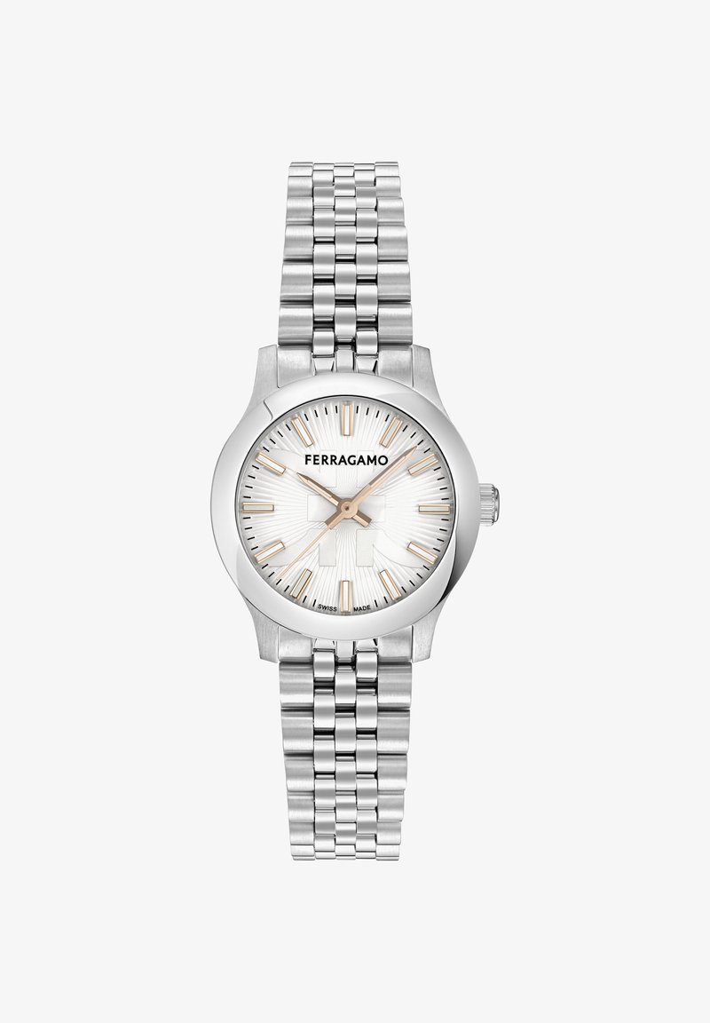 Roostevabast terasest Ferragamo randmevariant hõbedase kellapinnaga, kuldse tooniga tunnimarkerite, kolme käe ja seotud metallist käevõruga.