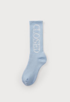 Hellblauer, gerippter Socke mit dem Wort "CLOSED" in Weiß. Das Design umfasst einen strukturierten oberen Bereich und eine glatte Zehenpartie.