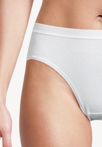 Weißer Baumwollslip mit nahtlosem Design, ausgestattet mit einem weichen Gummibund und glatter Textur, vor einem neutralen Hintergrund präsentiert.