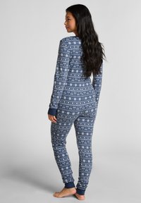 Ensemble de pyjama bleu marine en tissu doux, doté d'un motif géométrique blanc ; manches longues, coupe ajustée et poignets côtelés aux poignets et aux chevilles.