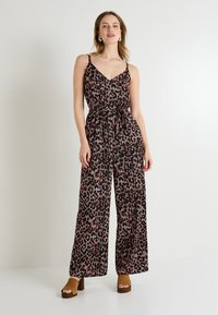 Mono negro con un estampado de leopardo en rojo y beige. Presenta un escote en V, diseño sin mangas y una cintura ajustada con lazo. Tejido texturizado.