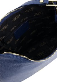 Blauwe leren tas met gepolijste leren binnenkant en zwarte voering, VENEZIA-logo, gouden rits en een enkele ritszak. Concaaf gevormde opening.