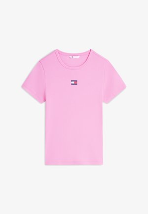 Růžové žebrované tričko s krátkým rukávem, kulatým výstřihem a malým logem Tommy Jeans uprostřed na hrudi.