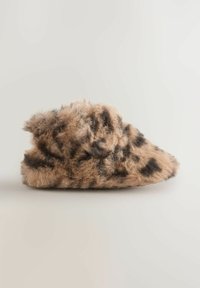 Chausson en fausse fourrure beige avec imprimé léopard noir. Forme arrondie, texture douce et haut bord pour le confort et la chaleur.