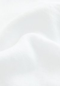 Fehér szövet, amely lágy, sima textúrájú, enyhe fényességgel, finom redőkkel, látható mintázat vagy szerelék nélkül.