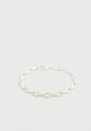 Srebrna bransoletka z łańcuszka z wydłużonymi owalnymi ogniwami i zapięciem typu karabińczyk na białym tle.