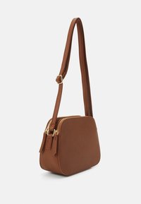 Hnědá syntetická křížová taška s hladkým povrchem, obdélníkovým tvarem, zlatými zipy a nastavitelným popruhem.