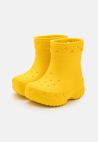 Stivali alla caviglia in gomma gialla con fori di ventilazione, suole robuste e superficie liscia; progettati per un utilizzo leggero e impermeabile.