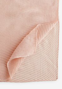 Tissu texturé de couleur rose, avec des stries visibles et un bord replié. Un subtil éclat et des accents dorés sont présents tout au long.