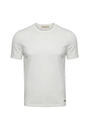 Maglietta bianca semplice a maniche corte con scollo tondo e piccolo marchio vicino all'orlo inferiore, esposta su uno sfondo semplice.