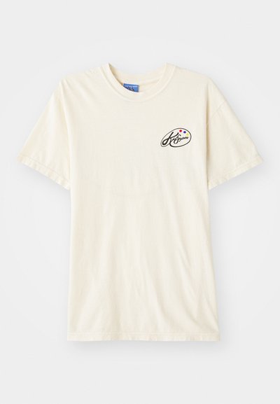 Cream-colored cotton t-shirt with a round neckline and short sleeves. Features a small logo in black and colored dots on the left chest.