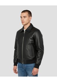 Schwarze Lederjacke mit Kragen, Frontreißverschluss und gestrickten Bündchen. Glatte Textur mit Seitentaschen und figurbetonter Silhouette.