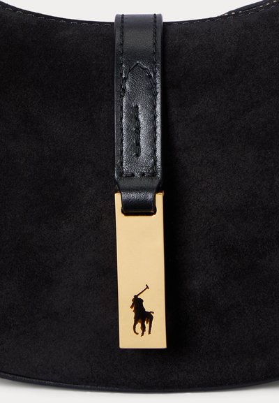 Juodos verstos odos rankinė su siūtu juodos odos dirželiu ir auksine stačiakampio formos metaline etiške su polo žaidėjo logotipu.