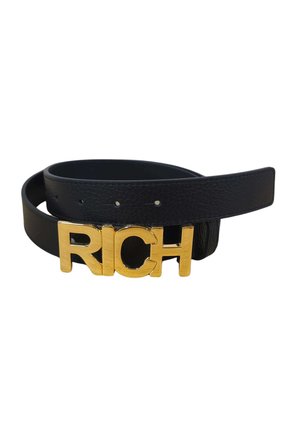 Cintura in pelle nera con una grande fibbia dorata che forma la parola RICH in lettere maiuscole, cintura parzialmente arrotolata.