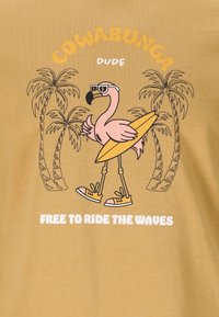 Gul t-shirt med en tecknad flamingo som bär solglasögon och håller en surfbräda, med palmträdsgrafik och texten "COWABUNGA DUDE."