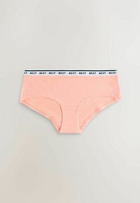 Culotte hipster pour femmes de couleur pêche douce avec une ceinture élastique blanche comportant le texte "NEXT" en noir répété.