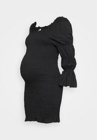 Veste de maternidade preta com textura franzida, decote à off-the-shoulder, mangas bufantes e barra com babados, projetada para um silhueta ajustada.