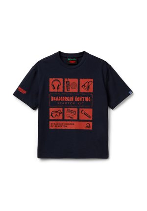 Marineblaue Stranger Things T-Shirt mit roten Grafiken, die Kopfhörer, Taschenlampe, Schutzbrille, Walkie-Talkie und den Text "Demogorgon Jagd-Starter-Set" zeigen.