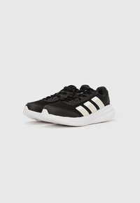 Mustad spordijalatsid valgete detailidega, võrkkatusega pealiskest, tugevdustega varbaosas ja pehmendatud tallaga. Külgedel on kolm valget triipu.