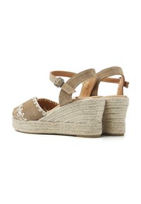 Bruine suède wedge sandalen met open teen, enkelbandje en geborduurd detail. Geweven jute plateau, omhuld met gevlochten materiaal.