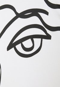 Weißer Stoff mit einer großen schwarzen Linienstudie eines Auges, das geschwungene Linien und glatte Details zeigt und hochkontrastierende Designelemente präsentiert.