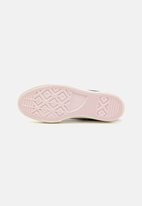 Schwarze Sneaker-Sohle mit einer strukturierten rosa Gummibasis, die geometrische Muster und einen weißen Rand aufweist.