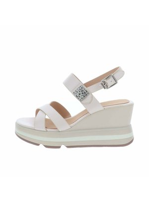 Sandale compensée beige avec deux brides à l’avant et une bride à la cheville avec une boucle argentée et une décoration en strass.