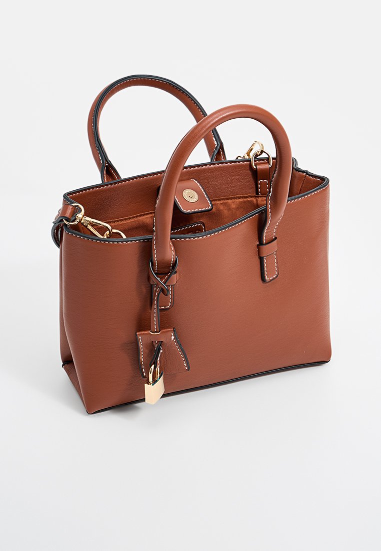 Sac en cuir marron avec double anses, forme élégante, quincaillerie dorée et couture blanche contrastante. Comprend un petit détail de cadenas.