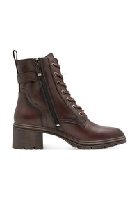 Bottes chevilles en cuir marron avec une surface texturée, fermetures à lacets et à glissière, et un talon épais à rainures. Dotées d'une sangle décorative.