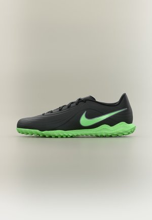 Chaussure de sport noire avec semelle vert fluo et logo Nike swoosh vert fluo sur le côté, conçue pour les sports sur gazon synthétique.