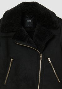 Giacca in ecopelle scura con colletto in morbido sherpa nero, tasche con zip dorate e design elegante. Etichettata come taglia S.